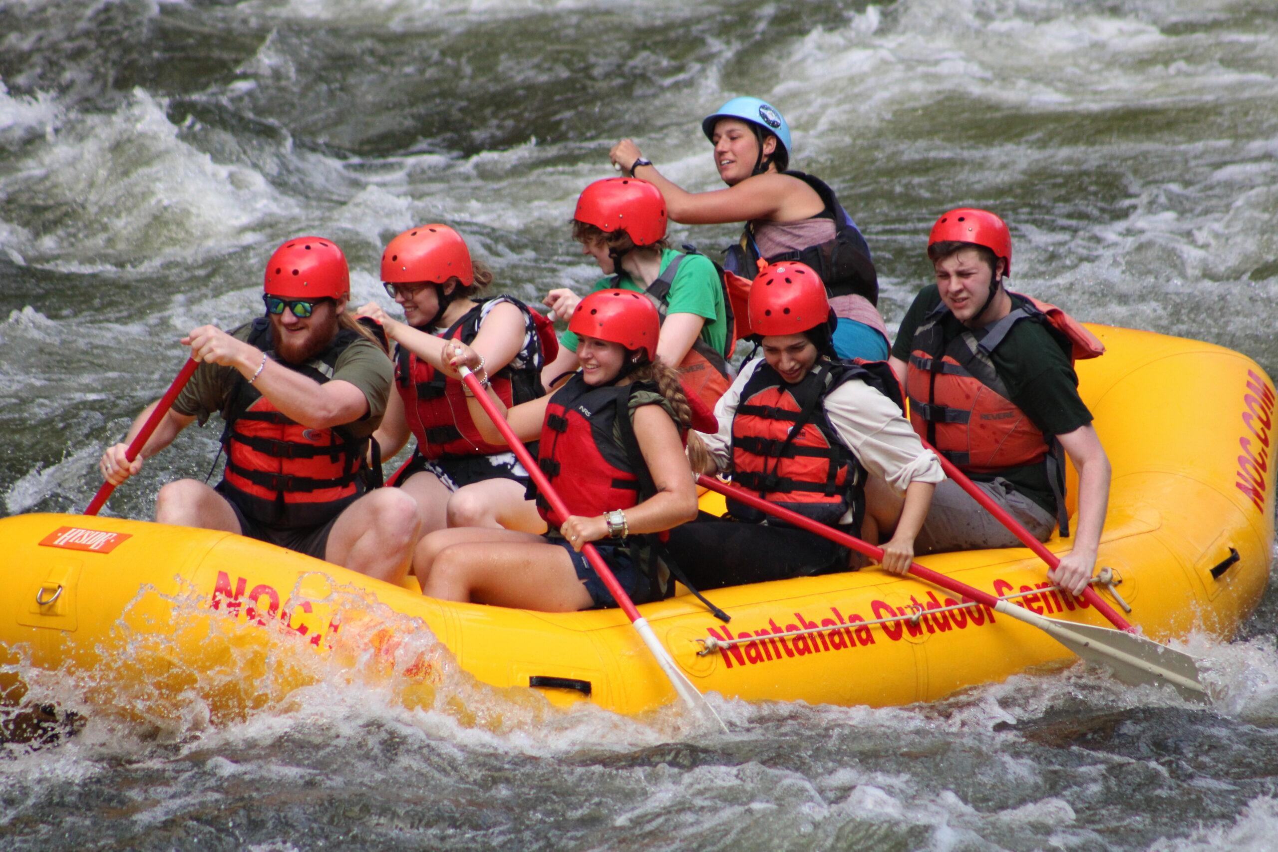 A group of college students white water rafting.